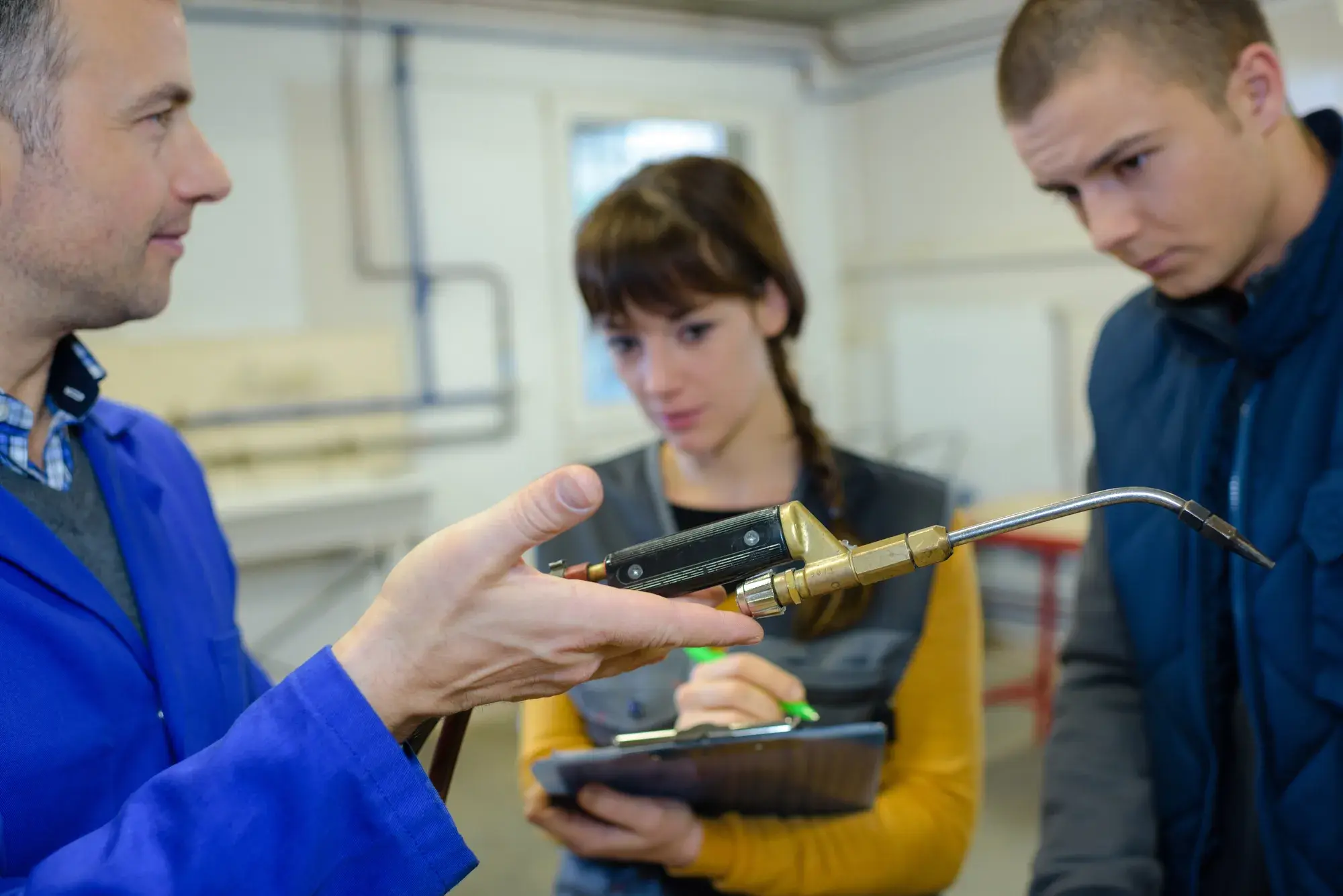 Ironworks teacher showing students how to safely use gas welder