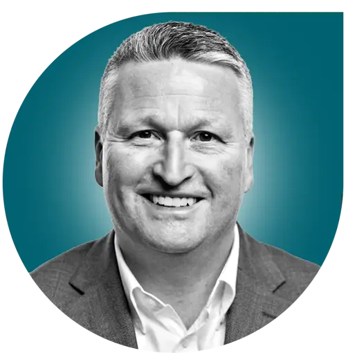 Portrait of Airgas expert Mike Joy, a smiling man in a suit jacket and white shirt, in front of a teal background.